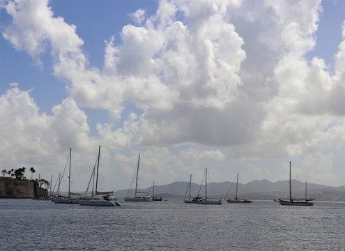Sailboats on the ocean with a beautiful blue sky and puffy white cloud background
