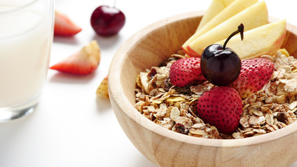 Oatmeal flakes, milk, and fresh fruits on white background.