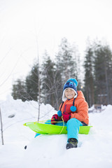 雪景色とソリで遊ぶ子供