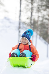 雪景色とソリで遊ぶ子供