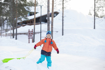 雪景色とソリで遊ぶ子供