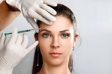Portrait of a young, beautiful woman getting botox cosmetic injection. A beautiful woman receives...