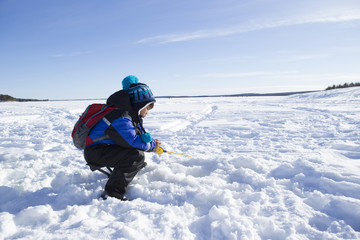 Fototapeta na wymiar 氷上釣りをする子供