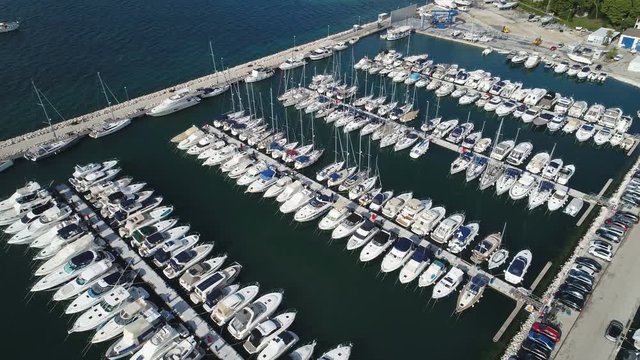 Tilting drone shot of motorboats, fishing vessels, and recreational yachts in busy marina in Biograd, coastal Croatia