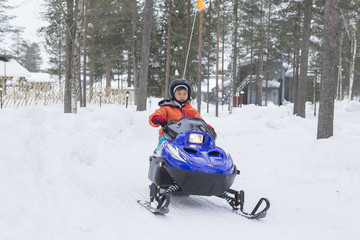 Fototapeta na wymiar スノーモービルに乗る子供　雪景色