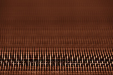 Detailed texture of engine water cooling radiator. Background image of orange automobile part with copy space close up.