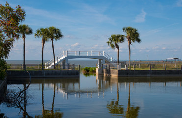 Fototapeta premium White bridge over the canal. Lake, fishermen are fishing.