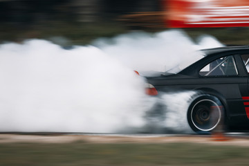 Sport car wheel drifting. Blurred of image diffusion race drift car with lots of smoke from burning...