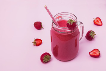 Healthy strawberry smoothie on the pink background