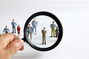 Magnifier and miniature people. Concepts for employment and recruitment.