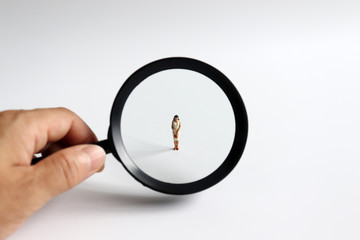 Magnifying glass and a miniature woman.