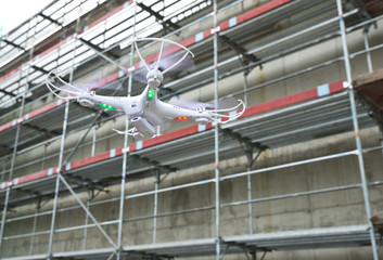 operator of the drone engineer at the construction site manages the flight and makes a video