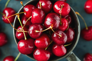 Top view of a bowl with ripe cherry over blue background. The concept of healthy organic food.