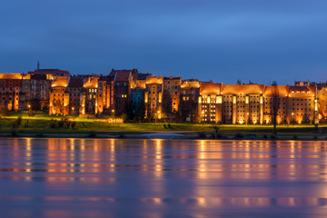 Obraz premium Granaries of Grudziadz at night reflected in Wisla river, Poland. Europe.