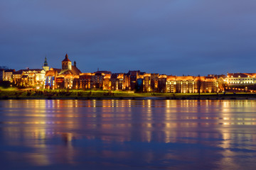Obraz na płótnie Canvas A view of Grudziadz at night reflected in Vistula river, Poland. Europe.