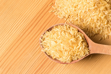 Old wooden spoon with rice on a wooden table. Close up. The concept of natural food