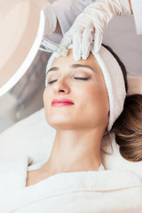 Close-up of the face of a woman relaxing during non-surgical facelift treatment in a contemporary beauty salon with innovative technology