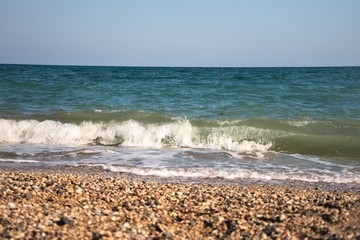 Black sea with waves on a pebbled beach