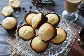 Freshly baked cupcakes in glass dish, Cup of cappuccino and manual coffee grinder