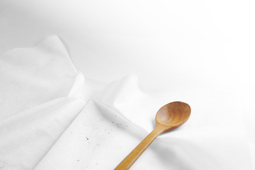 White tablecloth and wooden spoon.