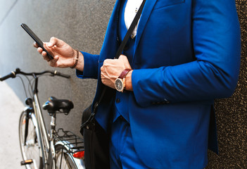 Close up of businessman hand holding phone and texting.