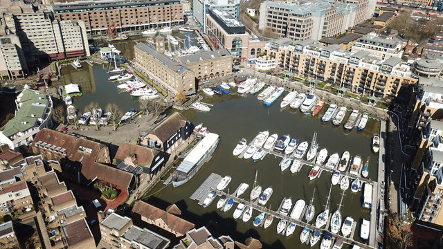 Aerial drone bird's eye view of famous St Katharine Docks Marina and iconic skyline in City of London, United Kingdom