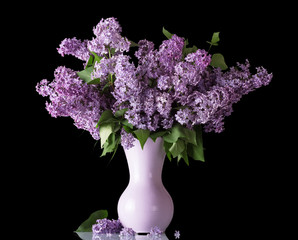 Beautiful bouquet of lilac in vase isolated on black