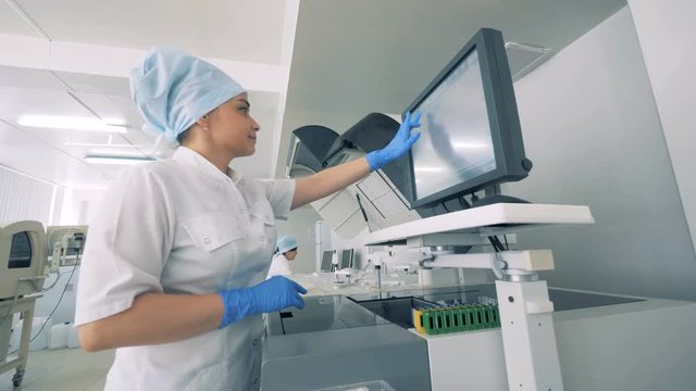 A nurse works with a monitor ina lab with a modern automated medical equipment.