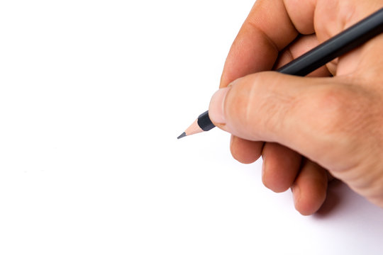 Man's hand holds a black pencil against white background, selective focus