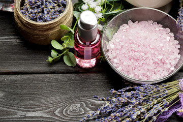 Obraz na płótnie Canvas Aromatic composition of lavender, herbs, cosmetics and salt on a dark table top