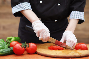 The cook cuts fresh farm vegetables