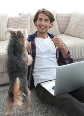 happy guy with laptop jubilant in spacious living room.