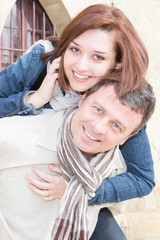 handsome Man giving piggyback ride to smiling woman