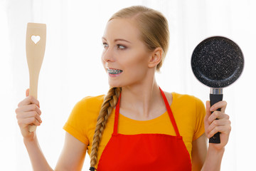 Woman holding cooking pan and spatula