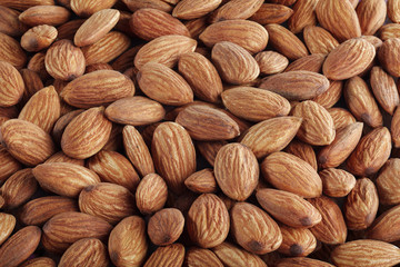Raw peeled almonds situated arbitrarily closeup. For vegetarians