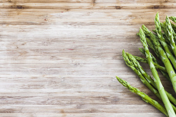 bunch of green asparagus on wooden board with copy space