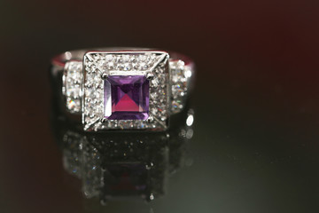 Purple gemstone on diamond ring