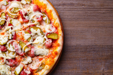 Fototapety  Klasyczna pizza Napoli z salami i korniszonami, popularna włoska przekąska z bliska z miejscem na kopię. Restauracja, dostawa żywności, koncepcja menu pizzerii.