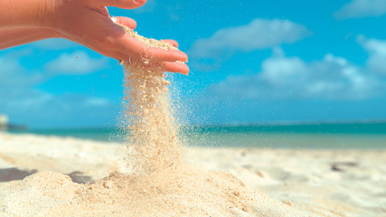 CLOSE UP: Gentle summer wind blows grains of white sand out of woman's hand. © helivideo