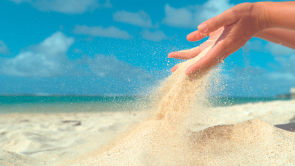 COPY SPACE: Small grains of sand slowly slip out of unrecognizable female hand. - obrazy, fototapety, plakaty