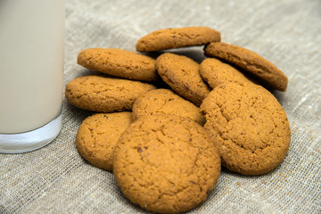 glass of milk and oatmeal cookies on a gray concrete background. Top view