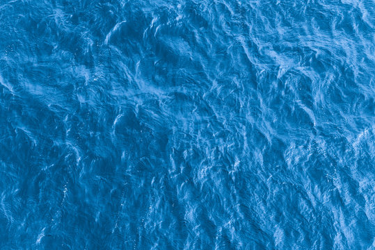 Beautiful sea background - blue water surface with small ripples, top view