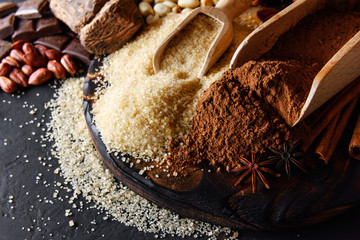 Cocoa powder, chocolate, nuts and spices on a wooden table. Food photography