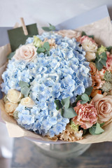 beautiful spring bouquet. flower arrangement with hydrangea. Color light blue. The concept of a flower shop, a small family business