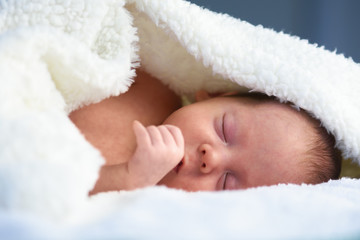 Newborn baby boy portrait on white carpet closeup. Motherhood and new life concept