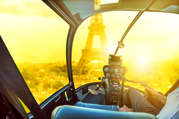 Helicopter cockpit interior flying on Tour Eiffel at sunset in Paris, France. Travel and tourism...