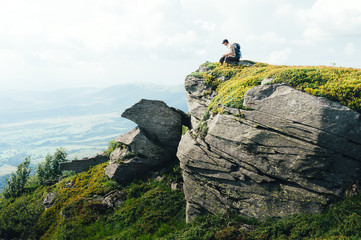 Alone tourist with backpack on rocks in high mountains. Landscape photography