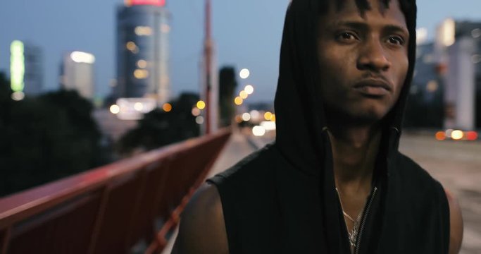 Sad man walking and thinking on a bridge in evening