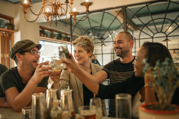 Group of friends cheering with drinks in a trendy bar