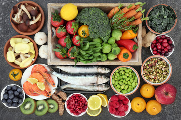 Health food selection with fresh sardines, vegetables, fruit, herbs and spices with foods high in omega 3 fatty acids, antioxidants, anthocyanins, fiber, minerals and vitamins.